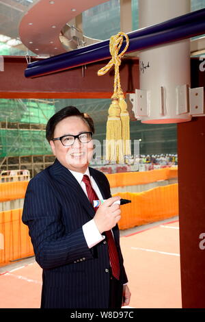 Wilfred Wong Ying-wai, président-directeur général de Sands China Ltd., pose à la cérémonie de l'achèvement du gros œuvre de la réplique de taille demi-tour Eiffel sur la const Banque D'Images