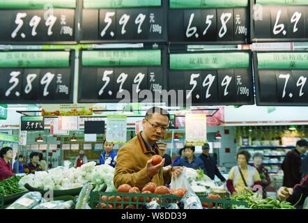 Les clients chinois acheter des légumes dans un supermarché de la ville de Hangzhou, Zhejiang Province de Chine orientale, le 10 novembre 2015. L'inflation des prix à la consommation de la Chine mod Banque D'Images