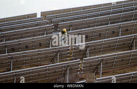 Un travailleur chinois installe des panneaux solaires à l'Wanjiashan Wanjiashan centrale photovoltaïque sur montagne dans le comté de Yanbian, Panzhihua ville, southwes Banque D'Images