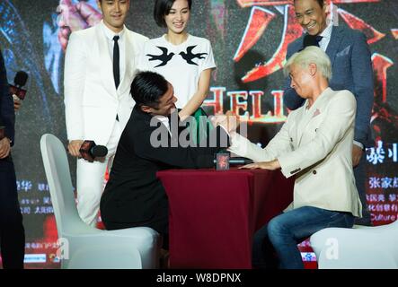 Hong Kong acteurs Nick Cheung, avant droit, et Shawn Yue au poignet du bras lors de la première du film 'Helios' à Beijing, Chine, 22 avril 2015. Banque D'Images