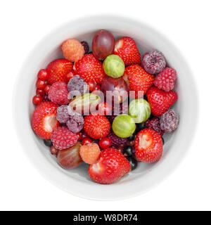 Petits fruits biologiques fraîchement cueillis dans un bol blanc isolé sur fond blanc, vue du dessus Banque D'Images