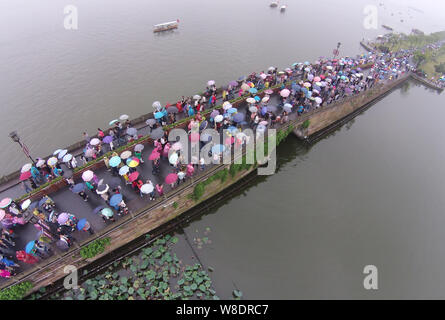 Les touristes des parasols à pied par le pont cassé sur le lac de l'Ouest dans la pluie dans la ville de Hangzhou, Zhejiang Province de Chine orientale, 4 octobre 2 Banque D'Images