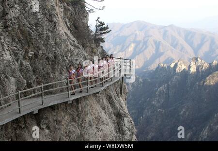 Modèles habillés en bikini à pied en talons hauts sur une promenade sur la falaise d'une montagne lors d'un concours de beauté dans Luanchuan county, le centre de la Chine Henan du Banque D'Images