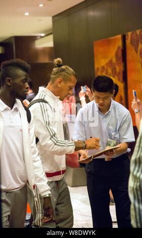 Hamady Niang M'baye, gauche, et Philippe Mexes, centre, de l'AC Milan arrivent à l'Aéroport International de Shanghai Pudong à Shanghai, Chine, 22 juillet 201 Banque D'Images