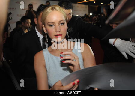 L'actrice américaine Jennifer Lawrence, centre, signe des autographes pour les fans lors d'une premiere pour son film 'The Hunger Games : Clarak - Part 2" à Pékin, Banque D'Images