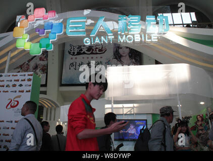 --FILE--un visiteur passe devant le stand de Mobile géant géant de groupe interactive lors d'une exposition à Beijing, Chine, 17 octobre 2014. O chinois Banque D'Images