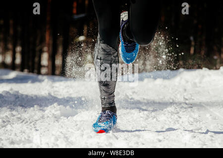 Athlète jambes runner running in winter snow trail Banque D'Images
