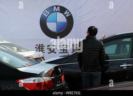 --FILE--un visiteur regarde les voitures au stand de BMW lors d'une exposition d'automobiles à Xuzhou, Jiangsu province de Chine orientale, le 13 décembre 2014. Banque D'Images