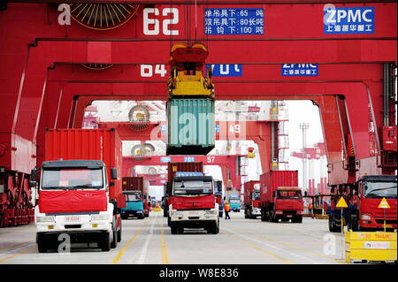 --FILE--conteneurs sont soulevés de camions et chargé sur un porte-conteneurs sur un quai du port de Qingdao en Qingdao city, Shandong province de la Chine de l'Est Banque D'Images