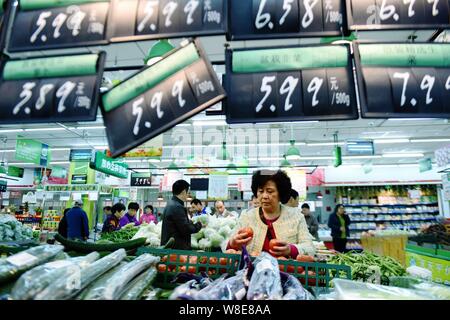 Les clients chinois acheter des légumes dans un supermarché de la ville de Hangzhou, Zhejiang Province de Chine orientale, le 10 novembre 2015. L'inflation des prix à la consommation de la Chine mod Banque D'Images