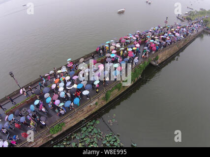 Les touristes des parasols à pied par le pont cassé sur le lac de l'Ouest dans la pluie dans la ville de Hangzhou, Zhejiang Province de Chine orientale, 4 octobre 2 Banque D'Images