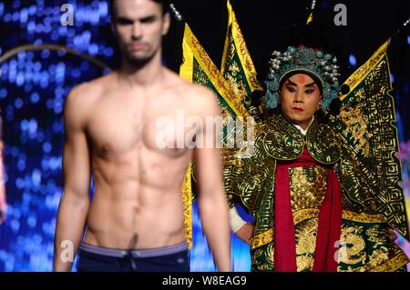 Un modèle en maillot affiche un sac de luxe comme un acteur d'opéra de Pékin effectue lors d'un fashion show à Jinan city, est de la Chine.s la province de Shandong, 11 N Banque D'Images