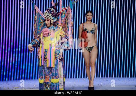 Un modèle en maillot affiche un sac de luxe comme un acteur d'opéra de Pékin effectue lors d'un fashion show à Jinan city, est de la Chine.s la province de Shandong, 11 N Banque D'Images