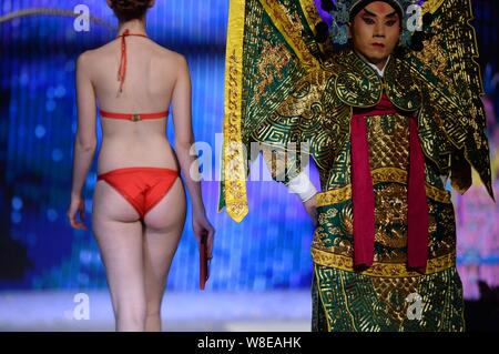 Un modèle en maillot affiche un sac de luxe comme un acteur d'opéra de Pékin effectue lors d'un fashion show à Jinan city, est de la Chine.s la province de Shandong, 11 N Banque D'Images