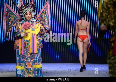 Un modèle en maillot affiche un sac de luxe comme un acteur d'opéra de Pékin effectue lors d'un fashion show à Jinan city, est de la Chine.s la province de Shandong, 11 N Banque D'Images