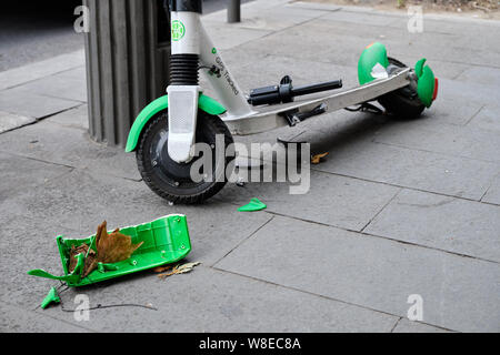Close up of gravement endommagé des Scooter électrique gauche sur trottoir suite à accident. Morceaux éparpillés et thorn roue arrière. Bucarest, Roumanie, Banque D'Images
