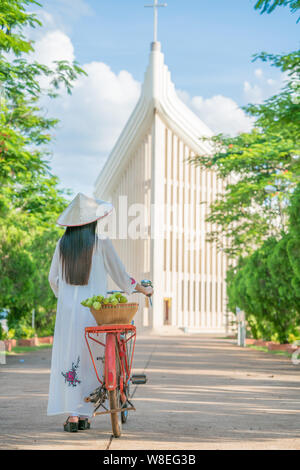 Belle femme avec le Vietnam culture tranditional Ao dai, robe et riding bicycle Banque D'Images