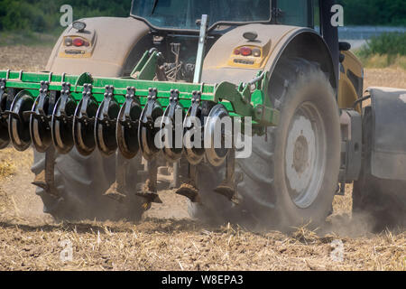 Tracteur jaune cultiver le champ Vue arrière libre Banque D'Images