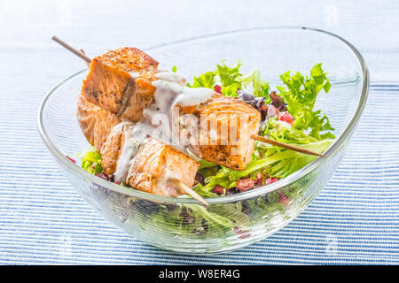 Les brochettes de saumon grillé avec de la laitue d'été salat pomehranate graines huile d'olive et vinaigrette. L'alimentation des poissons en bonne santé avec des fruits et légumes Banque D'Images