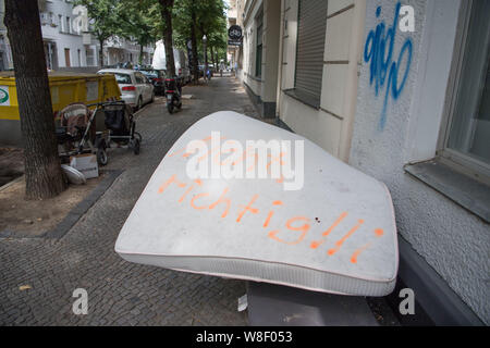 09 août 2019, Berlin : un matelas jetés illégalement se trouve sur un trottoir à Neukölln, sur elle les mots 'pas juste ! !' ont été pulvérisés. Dans le cadre de la lutte contre l'élimination des déchets depuis cet été 6 Kiezhausmeister sont sur le chemin dans le district, qui lutte pour une vie propre et d'une valeur de Neukölln. Ils informent les citoyens, organiser des festivals de déchets en vrac dans les quartiers, faire des campagnes de nettoyage avec les associations et les dépôts de déchets Rapport du bureau de l'ordre public. Photo : Jörg Carstensen/dpa Banque D'Images