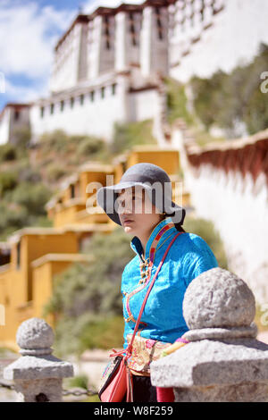 --FILE--une femme habillé en costume tibétain pose pour les photos sur le Palais du Potala à Lhassa, le sud-ouest de la Chine, région autonome du Tibet, 11 octobre 2014. Banque D'Images