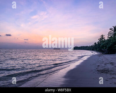 Magnifique coucher de soleil dans l'océan sur l'île Fehendhoo, Maldives Banque D'Images