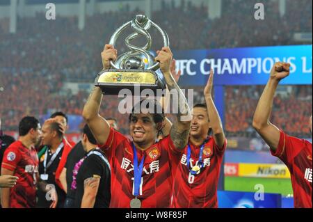 Ricardo Goulart de Guangzhou Evergrande de la Chine, avant, soutient le trophée de champion de la Ligue des Champions de l'AFC 2015 alors qu'il célèbre avec son teamma Banque D'Images