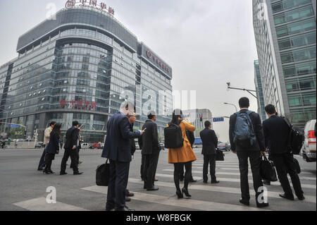 --FILE--piétons attendre à traverser une route en face de l'édifice du siège social de Chine Huarong Asset Management Co., Ltd. à Beijing, Chine, 15 avril Banque D'Images