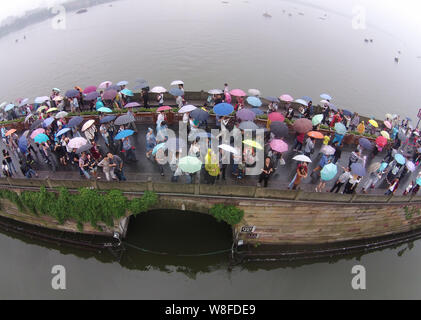 Les touristes des parasols à pied par le pont cassé sur le lac de l'Ouest dans la pluie dans la ville de Hangzhou, Zhejiang Province de Chine orientale, 4 octobre 2 Banque D'Images
