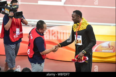 Usain Bolt médaille d'or de la Jamaïque, droite, serre la main avec le caméraman qui frappa plus d'avec un Segway-comme deux roues scooter après receivin Banque D'Images