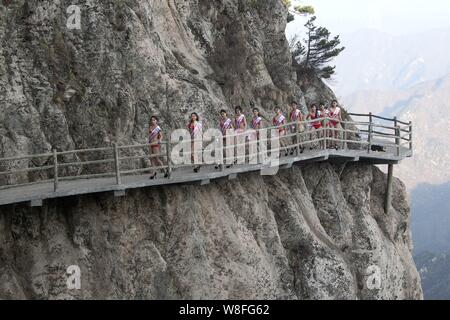 Modèles habillés en bikini à pied en talons hauts sur une promenade sur la falaise d'une montagne lors d'un concours de beauté dans Luanchuan county, le centre de la Chine Henan du Banque D'Images