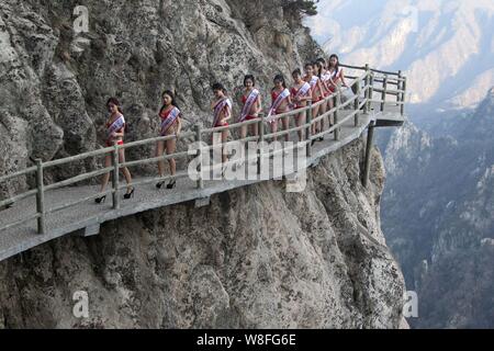 Modèles habillés en bikini à pied en talons hauts sur une promenade sur la falaise d'une montagne lors d'un concours de beauté dans Luanchuan county, le centre de la Chine Henan du Banque D'Images