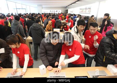 Employés chinois de présenter Apple ordinateurs portables pour les clients au nouvel Apple Store dans la ville de Shenyang, au nord-est de la province de Liaoning, Chine Banque D'Images