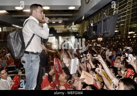 La star du football italien Fabio Cannavaro, haut, ancien entraîneur en chef de la Chine Guangzhou Evergrande FC Taobao, interagit avec les fans chinois avant de quitter Ch Banque D'Images