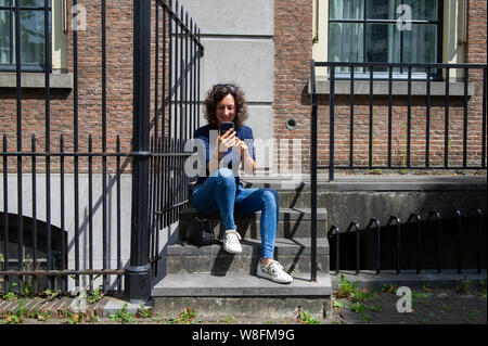 Den Haag. Een jonge vrouw op een trapje. Foto : Gerrit de Heus. Les Pays-Bas. Une jeune femme. Photo : Gerrit de Heus. Banque D'Images