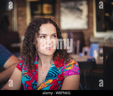 Une photo de style de vie en gros d'une jeune femme brune caucasienne qui s'est socialisée dans un restaurant. Banque D'Images