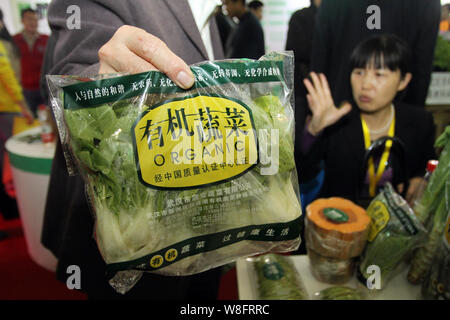 Visiteurs acheter des légumes biologiques sur un stand lors de la 8e Wuhan Chine Agriculture Expo à Wuhan, province du Hubei en Chine centrale, 5 novembre 2011. Banque D'Images