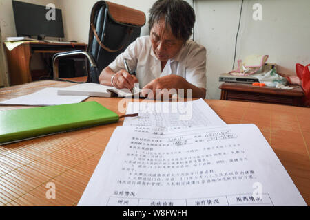 (190809) -- NANCHANG, 9 août 2019 (Xinhua) -- Gao Yinshui reviews prend des notes sur l'enregistrement des patients dans la région de Lixin Village de Meiling dans la ville de Nanchang District Wanli, Ville de la Province de Chine orientale, le 8 août 2019. Presque tous les jours au cours des quatre dernières décennies, 69 ans, médecin de village Yinshui Gao promenades pour miles sur les routes de montagne pour voir ses patients dans 9 villages différents. À la fin de 1970, la mère de Gao avait une urgence et a eu la chance d'être sauvé par un médecin rural local. À cause de cela, Gao Yinshui a renoncé à l'occasion d'être un enseignant et a choisi de devenir un médecin rural. Cependant, elle a Banque D'Images