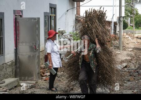 (190809) -- NANCHANG, 9 août 2019 (Xinhua) -- Gao Yinshui accueille un villageois sur son chemin à une visite à domicile dans la région de Lixin Village de Meiling dans la ville de Nanchang District Wanli, Ville de la Province de Chine orientale, le 8 août 2019. Presque tous les jours au cours des quatre dernières décennies, 69 ans, médecin de village Yinshui Gao promenades pour miles sur les routes de montagne pour voir ses patients dans 9 villages différents. À la fin de 1970, la mère de Gao avait une urgence et a eu la chance d'être sauvé par un médecin rural local. À cause de cela, Gao Yinshui a renoncé à l'occasion d'être un enseignant et a choisi de devenir un médecin rural. Cependant, elle Banque D'Images