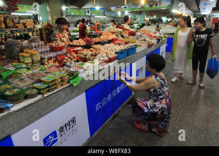 Un client chinois de scanner un QR code via le service de paiement mobile du Groupe d''Alibaba Alipay sur son smartphone, pour payer son achat à un marché libre pour nous Banque D'Images