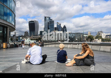 Londres, Royaume-Uni. 9 Août, 2019. Siège personnes sur un banc au London Riverside en vue de la ville de London financial district.L'Office National des Statistiques a indiqué que, l'économie britannique se réduit pour la première fois depuis 2012 que la croissance du PIB a diminué de 0,2 %, la production manufacturière a chuté et le secteur de la construction affaiblie. Credit : Amer Ghazzal SOPA/Images/ZUMA/Alamy Fil Live News Banque D'Images