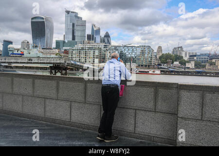 Londres, Royaume-Uni. 9 Août, 2019. Un homme utilise un smartphone de l'autre côté de la ville de London financial district.L'Office National des Statistiques a indiqué que, l'économie britannique se réduit pour la première fois depuis 2012 que la croissance du PIB a diminué de 0,2 %, la production manufacturière a chuté et le secteur de la construction affaiblie. Credit : Amer Ghazzal SOPA/Images/ZUMA/Alamy Fil Live News Banque D'Images