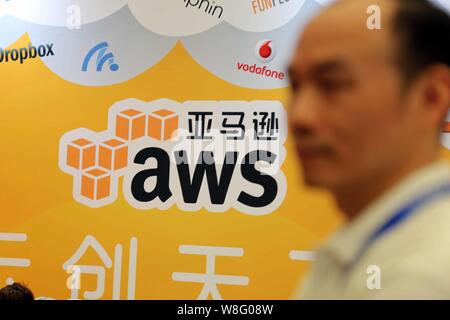 --FILE--un employé chinois passe devant le stand d'AWS (Amazon Web Services) lors de la 13e China Digital Entertainment Expo, également connu sous le nom de ChinaJoy Banque D'Images