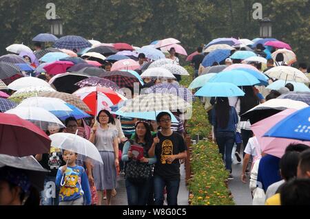 Les touristes des parasols à pied par le pont cassé sur le lac de l'Ouest dans la pluie dans la ville de Hangzhou, Zhejiang Province de Chine orientale, 4 octobre 2 Banque D'Images