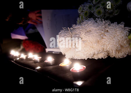 Un Chinois jette des fleurs pour les victimes du 13 novembre Paris les attaques à l'Ambassade de France à Pékin, Chine, 14 novembre 2015. Banque D'Images