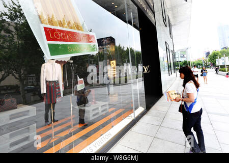 --FILE--piétons devant une boutique de mode de Louis Vuitton (LV) à Shanghai, Chine, 30 mai 2015. LVMH Moet Hennessy Louis Vuitton se dit Mond Banque D'Images