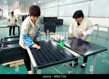 --FILE--femmes travailleurs chinois nettoyer les panneaux solaires à l'usine de Shanghai Hilight-Solar Co., Ltd. à Binzhou Zouping county, ville, est de la Chine, Shand Banque D'Images