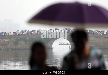 Les touristes des parasols à pied par le pont cassé sur le lac de l'Ouest dans la pluie dans la ville de Hangzhou, Zhejiang Province de Chine orientale, 4 octobre 2 Banque D'Images