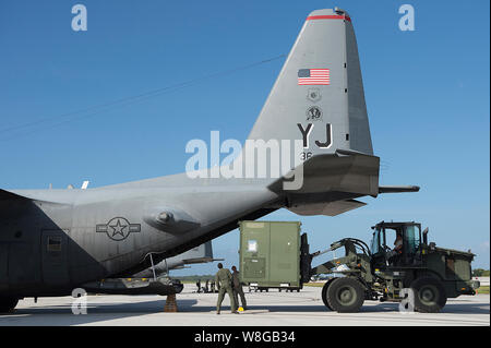 Les aviateurs de l'US Air Force à partir de la 36e groupe le Plan d'intervention et le 36e Escadron de transport aérien, conteneurs sur un C-130 Hercules au cours d'un humanitaire Banque D'Images