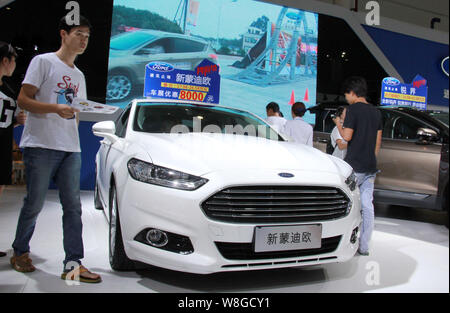 --FILE--visiteurs examiner une nouvelle Mondeo de Ford à l'écran lors d'une auto show de Haikou City, province de Hainan en Chine du Sud, 10 juillet 2015. L'expérience de Ford Banque D'Images